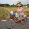 Farmer lady riding bike.